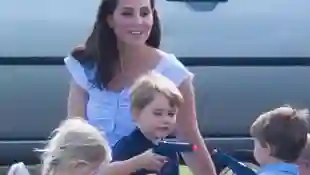 Prinz George spielt mit einer Pistole, während Herzogin Kate zusieht
