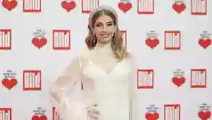 Cathy Hummels in einem weißen Kleid und mit Glitzer-Haarreif bei einem Event im Dezember 2022