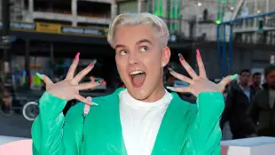 Twenty4tim zeigt seine bunten Fingernägel auf dem roten Teppich