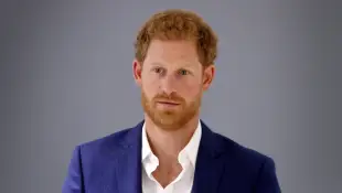 Prince Harry stands against a gray background in September 2017