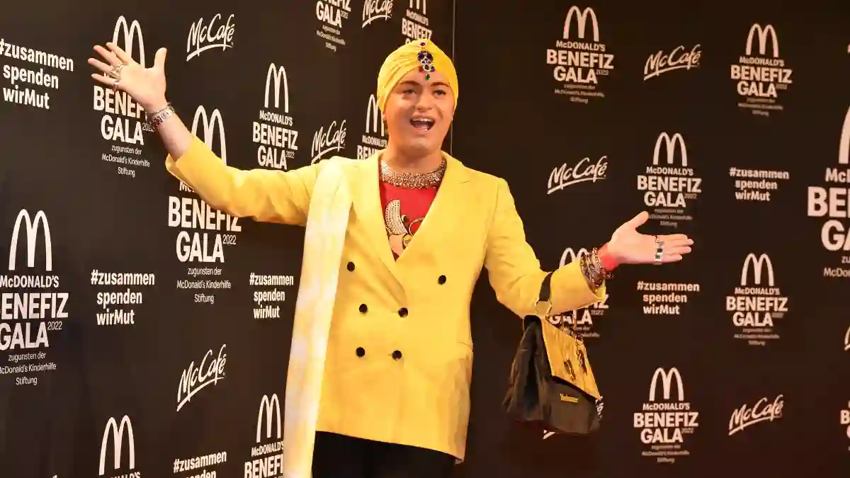 Julian F. M. Stoeckel in einem gelben Blazer und mit gelbem Kopftuch bei der McDonald's Benefiz Gala 2022