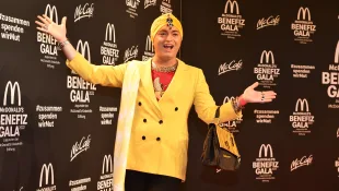 Julian F. M. Stoeckel in einem gelben Blazer und mit gelbem Kopftuch bei der McDonald's Benefiz Gala 2022