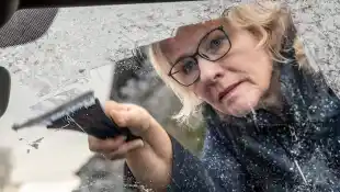 Eiskratzen am Morgen, Autofahrerin macht die Windschutzscheibe ihres Autos frei, München, Dezember 2024