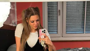 Anne Wünsche macht ein Selfie von sich auf dem Bett