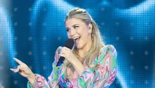 Beatrice Egli singt lächelnd auf der Bühne im Sommer 2023