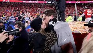 Taylor Swift und Travis Kelce küssend auf dem Spielfeld