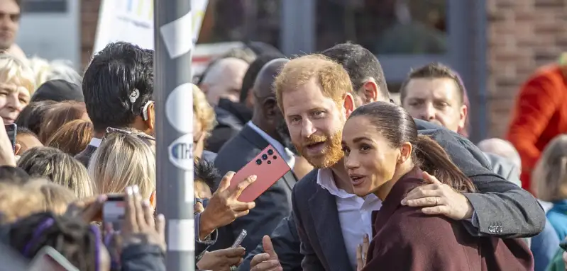 Prinz Harry legt seinen Arm schützend um Meghan.