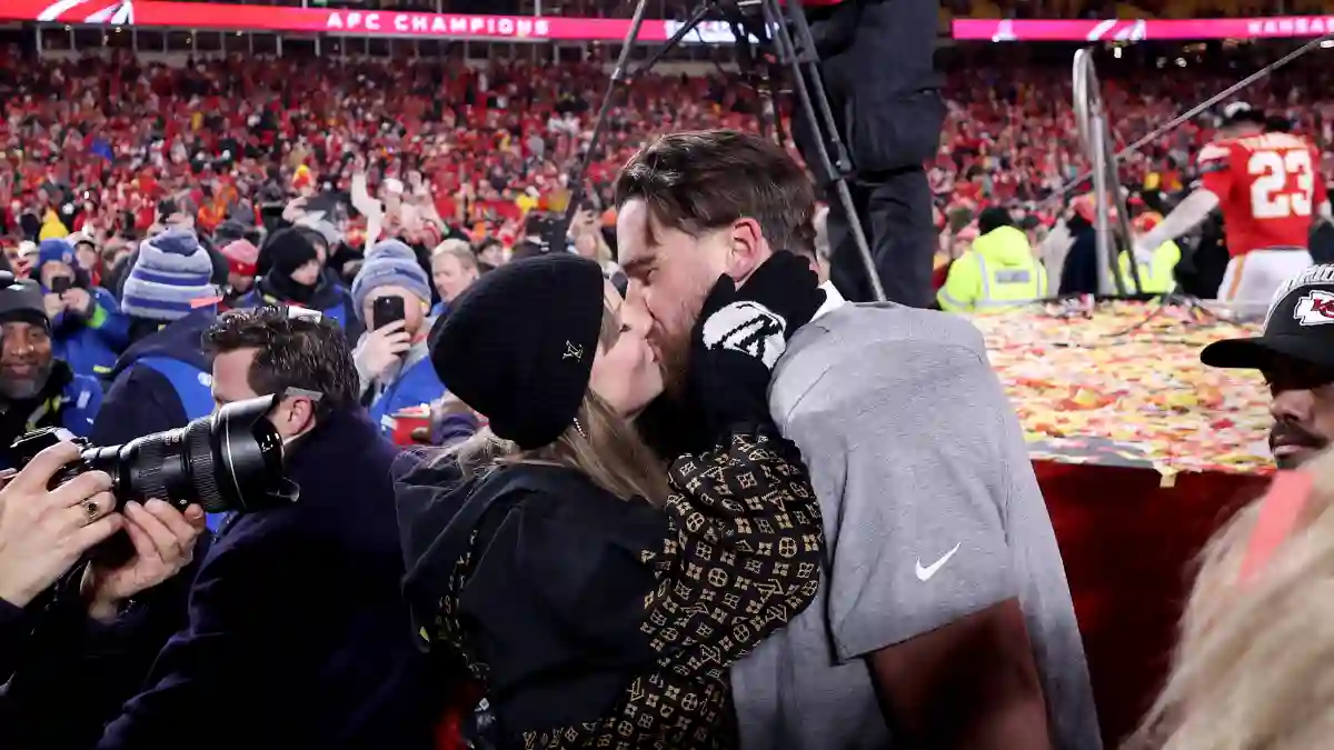 Taylor Swift und Travis Kelce küssend auf dem Spielfeld