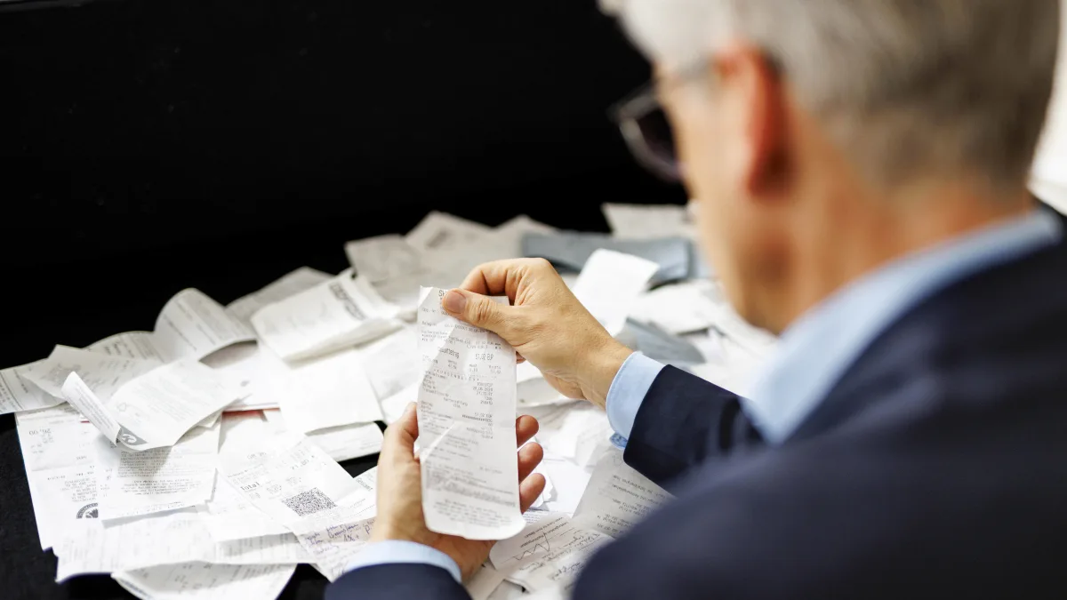 Steuern: Ein Mann hält Belege in der Hand
