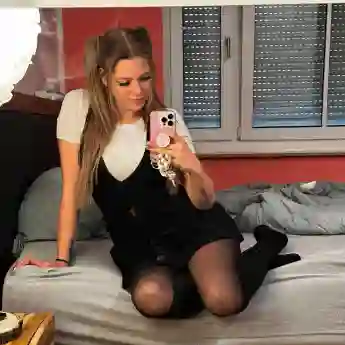 Anne Wünsche macht ein Selfie von sich auf dem Bett