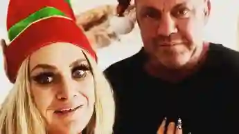Caro und Andreas Robens posieren mit Weihnachtsmützen für ein Instagram-Selfie