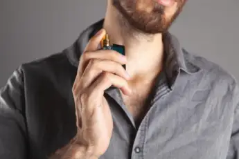 Mann sprüh sich mit Parfum ein