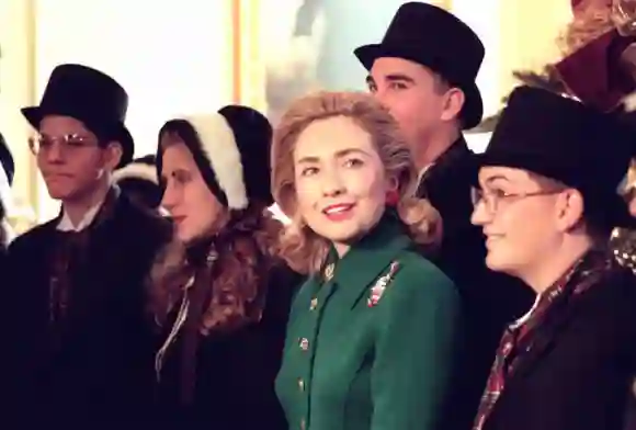 First Lady Hillary Clinton posiert mit traditionellen Weihnachtssängern im East Room des Weißen Hauses