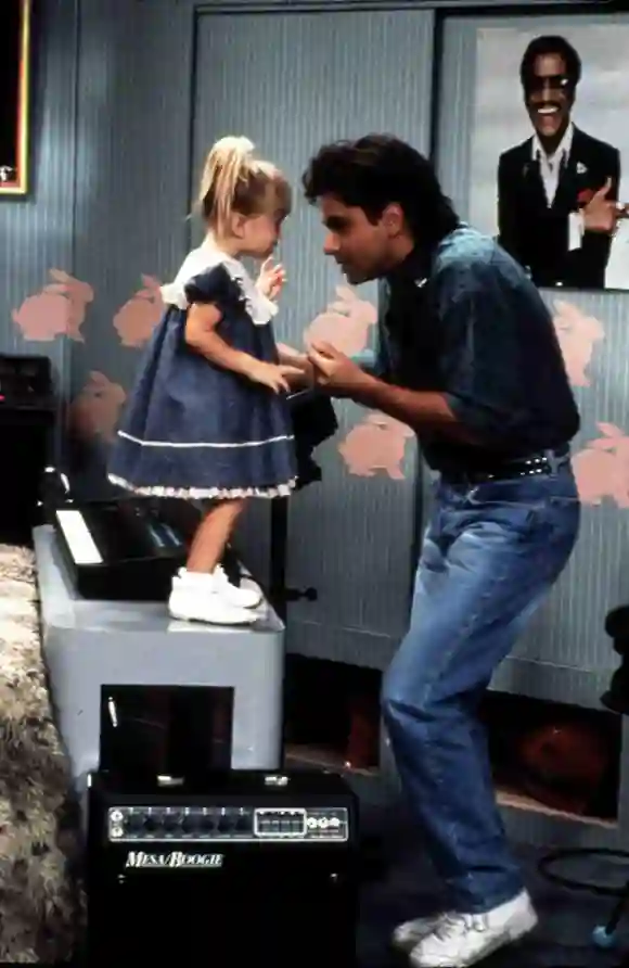 John Stamos alias „Jesse“ tanzt mit einem der Olsen-Zwillinge in „Full House“