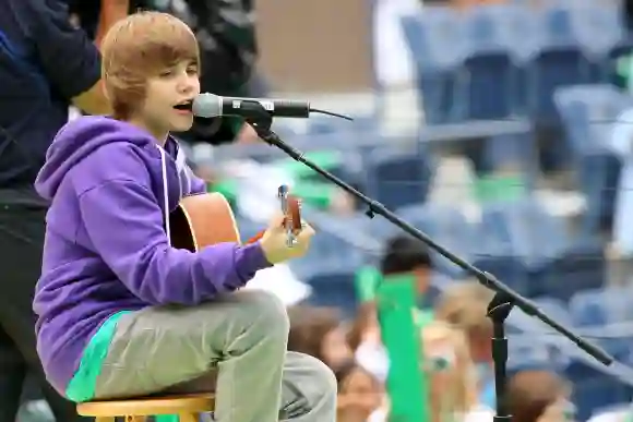 Justin Bieber singt in jungen Jahren mit Gitarre auf der Bühne