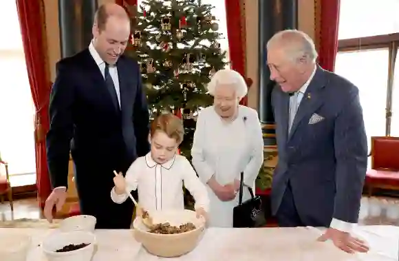 Prinz William, Prinz George, Königin Elisabeth II. und Prinz Charles bereiten im Buckingham Palace Christmas Pudding zu 2019