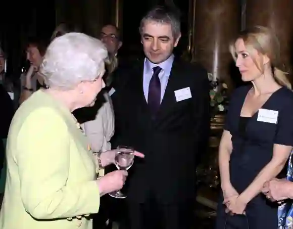 Königin Elisabeth II. trifft den Schauspieler Rowan Atkinson und die Schauspielerin Gillian Anderson bei einem Empfang am 14. Februar 2012