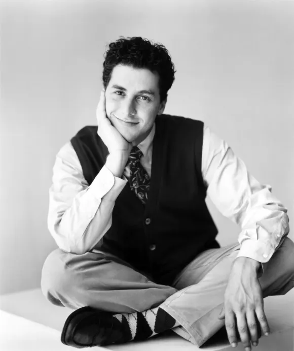 Corey Parker lächelt im Schneidersitz