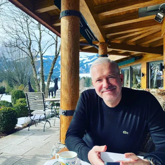 Alexander Herrmann sitzt am Tisch und lächelt in die Kamera für ein Instagram-Foto