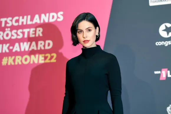 Lena Meyer-Landrut in einem schwarzen Kleid und mit rotem Lippenstift bei einem Event im Dezember 2022